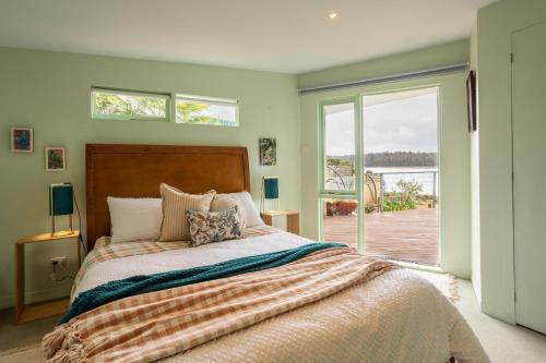 1 dormitorio con cama y ventana grande en Smuggler's Hideaway, riverfront Tamar Valley, en Blackwall