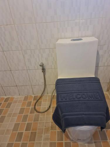 a toilet with a blue seat in a bathroom at Sleep Pai Bed & Breakfast in Pai