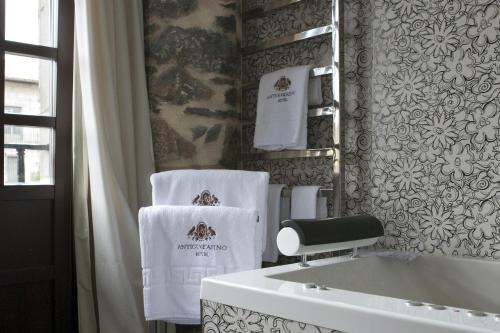 - Baño con lavabo y toallas en la pared en Antiguo Casino Hotel, en Pravia