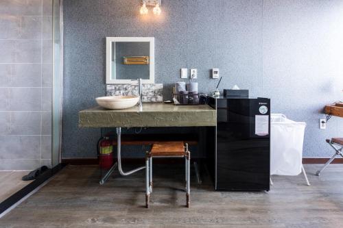 a bathroom with a counter with a sink and a mirror at Aqua Beautique Poolvilla in Jeju
