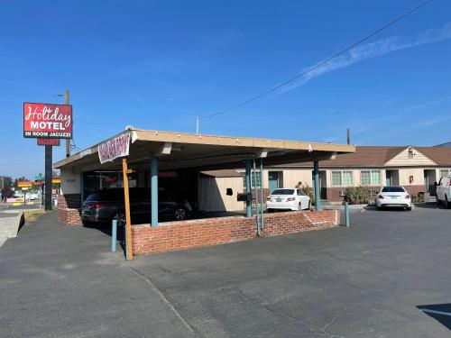 ein Gebäude mit einer Garage auf einem Parkplatz in der Unterkunft Holiday Motel in Portland