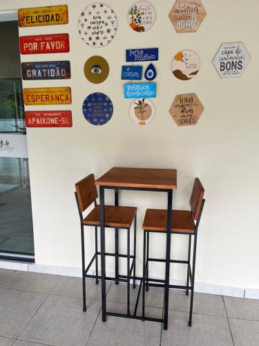 a table and two chairs in front of a wall with signs at POUSADA ACONCHEGO MT in Chapada dos Guimarães