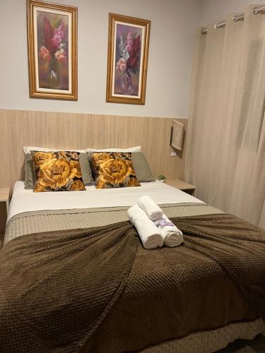 a bedroom with a bed with two towels on it at POUSADA ACONCHEGO MT in Chapada dos Guimarães
