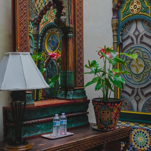 a table with a lamp and two water bottles on it at La Casa de la Marquesa in Querétaro