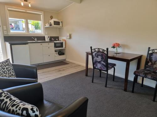 a living room with a table and chairs and a kitchen at Cheviot Motels, Cabins and Camp in Cheviot