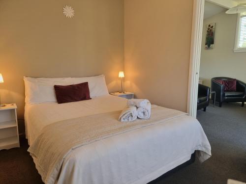 a bedroom with a bed with towels on it at Cheviot Motels, Cabins and Camp in Cheviot