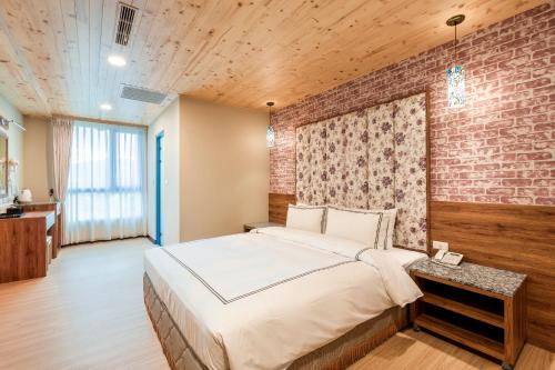 a bedroom with a large bed and a brick wall at San Chiao Hotel in Daxi
