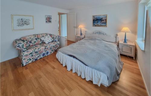 a bedroom with a bed and a couch at Nice Home In Uddevalla With Wifi And 3 Bedrooms in Uddevalla