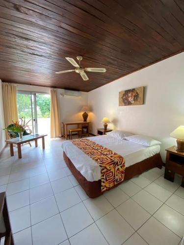 a bedroom with a bed and a wooden ceiling at Hotel Santo Vanuatu in Luganville