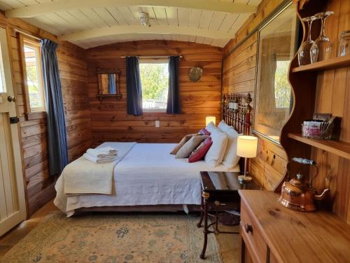 una camera con un letto in una cabina di legno di Cheviot Motels, Cabins and Camp a Cheviot