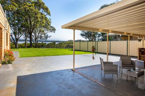 a pavilion with chairs and a table on a patio at Enchante` - Pet Friendly - Absolute Waterfront - Fireplace in Culburra Beach