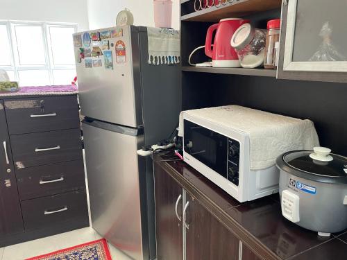 a kitchen with a microwave and a refrigerator at Has Hills Residence - 2 BEDROOMS CONDO with WiFi in Kajang