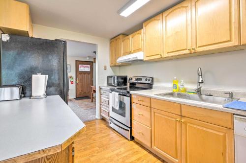 a kitchen with wooden cabinets and a black refrigerator at Walkable Sitka Getaway with Community Perks! in Sitka