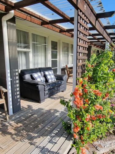 a patio with a black leather couch on a deck at Cheviot Motels, Cabins and Camp in Cheviot