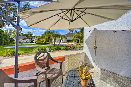 a patio with a chair and an umbrella at The Shell House in Titusville Pool, Golf Access in Titusville