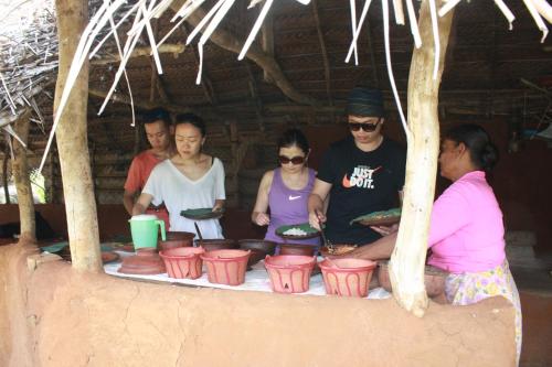 a group of people standing around a table at CAMPING BY LUCKY HOLIDAY in Mirigama