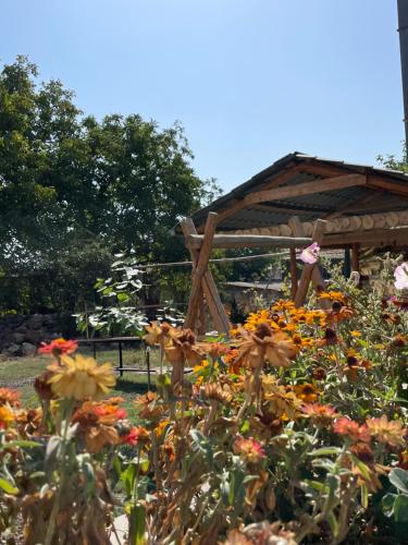 a garden with flowers in front of a gazebo at Liga Hotel and Restaurant in Shinuhayr