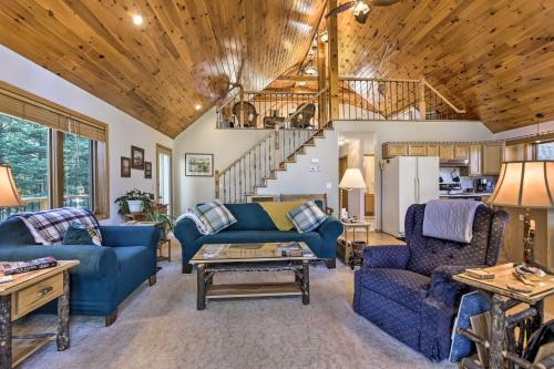 a living room with blue furniture and a wooden ceiling at Elcho Escape with Private Dock on Post Lake! in Elcho