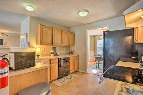 a kitchen with wooden cabinets and a black refrigerator at 9 Mi to Richmond Sandston Home with Office in Sandston