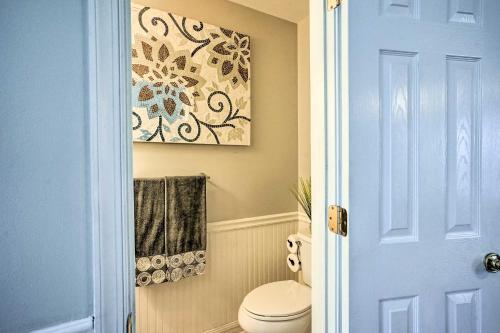 a bathroom with a toilet and a painting on the wall at 9 Mi to Richmond Sandston Home with Office in Sandston