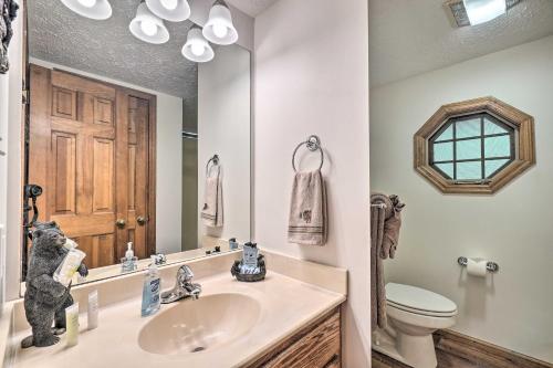 a bathroom with a sink and a toilet and a mirror at Picturesque Pigeon Forge Cabin with Mountain Views in Pigeon Forge