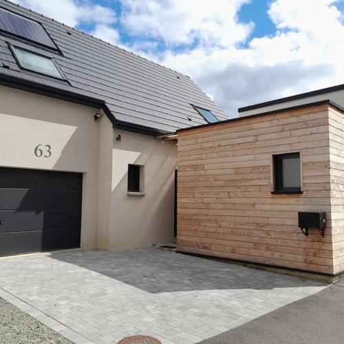 uma casa com garagem e um edifício em Joli studio avec stationnement gratuit dans la rue em Le Mans