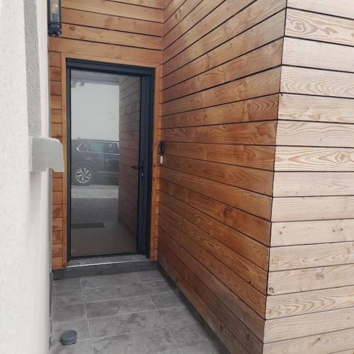 uma parede de madeira com uma porta que leva a uma garagem em Joli studio avec stationnement gratuit dans la rue em Le Mans