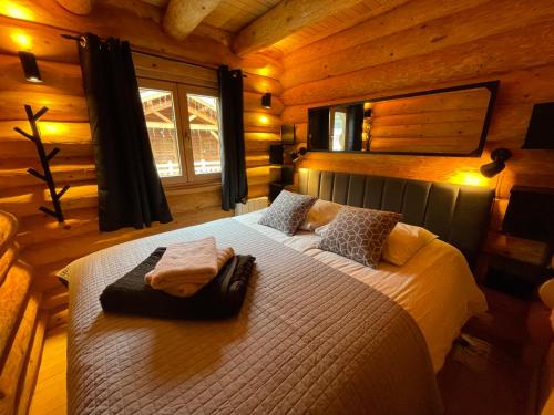 a bedroom with a large bed in a cabin at Le ZEN in Allos