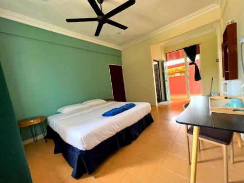 a bedroom with a bed with a ceiling fan at papaya resort in Kampung Tekek