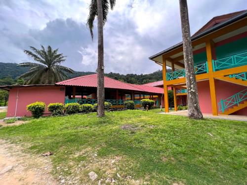 a building with palm trees in front of it at papaya resort in Kampung Tekek