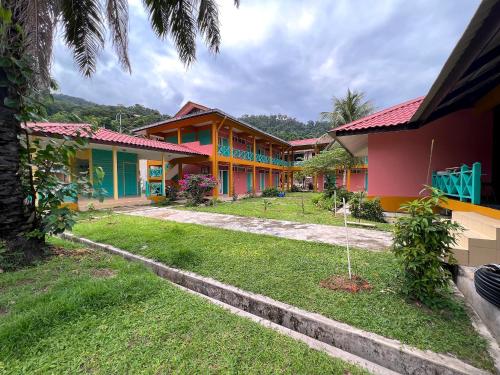 a row of colorful houses in a yard at papaya resort in Kampung Tekek