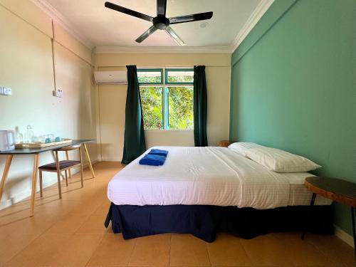 a bedroom with a bed and a table and a window at papaya resort in Kampung Tekek