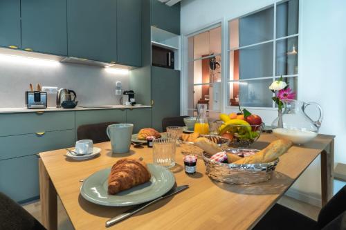 une table avec une assiette de pain et une corbeille de fruits dans l'établissement Louvre Montorgueil, à Paris