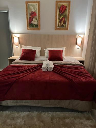 a bedroom with a large bed with two towels on it at POUSADA ACONCHEGO MT in Chapada dos Guimarães