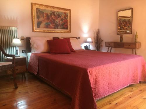 a bedroom with a large bed with a red blanket at Sarakinas Farm House in Kalabaka