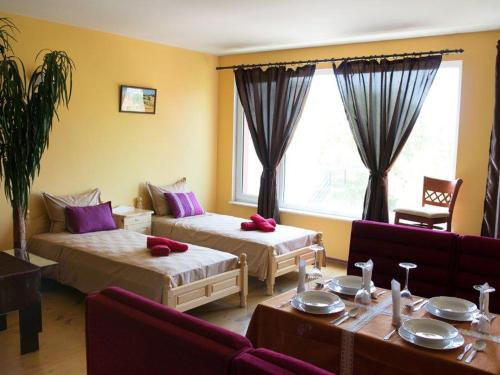 a hotel room with two beds and a table at Villa Sunny Hill in Fish Fish
