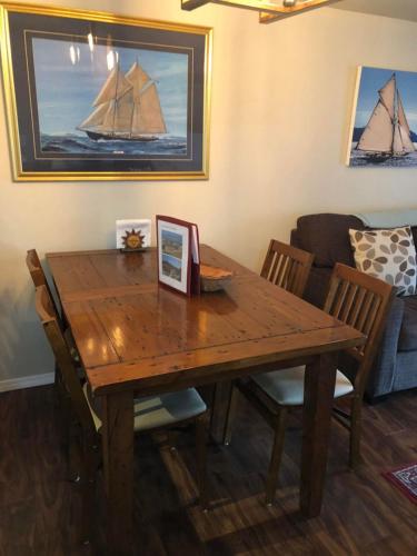 a wooden dining room table with chairs and a boat on the wall at Copper Suite Family Friendly 2 Bed with Amenities in Invermere
