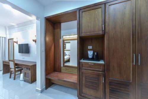 a dressing room with wooden cabinets and a desk at HOTEL WHITE HOUSE, Munnar in Munnar