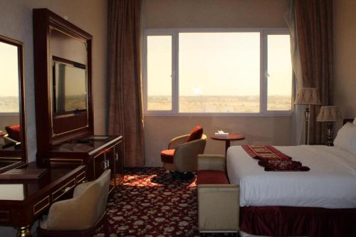 a hotel room with a bed and a large window at Al Salam Grand Hotel in Al Buraymī