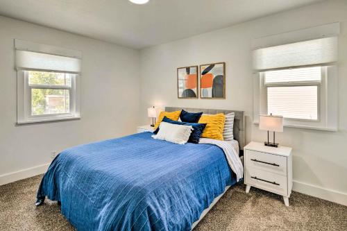- une chambre avec un lit bleu et 2 fenêtres dans l'établissement Cozy and Modern SLC Home Yard, 6 Mi to Dtwn!, à Salt Lake City