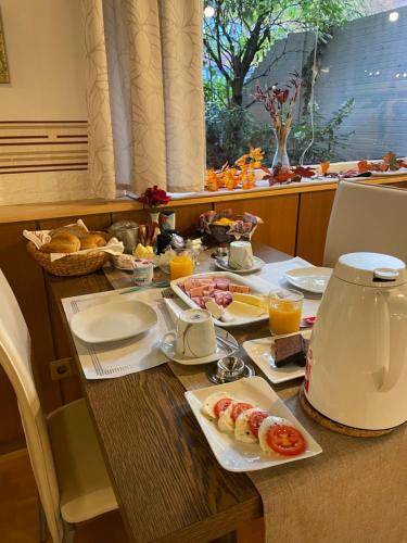 einen Frühstückstisch mit Frühstückszutaten und Orangensaft in der Unterkunft Hotel Bölke in Wunstorf