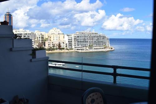a balcony with a view of the ocean and buildings at Saint Julians Seafront 200m2 beautiful Apartment in Tal-Għoqod