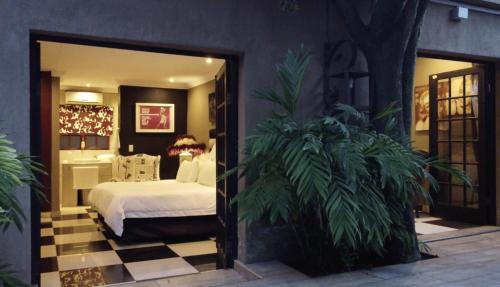 a bedroom with a bed and a checkered floor at Little Eden Guest Lodge in Vanderbijlpark