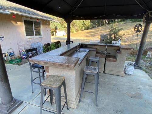 a large outdoor kitchen with stools and an umbrella at Waxberry Getaway Sequoia/Kings Canyon National Pks in Squaw Valley
