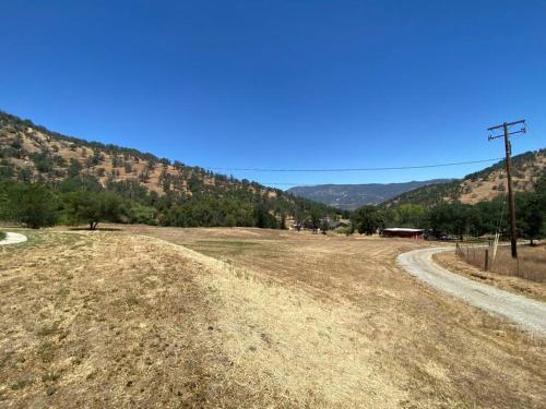 a dirt road in a field with mountains in the background at Waxberry Getaway Sequoia/Kings Canyon National Pks in Squaw Valley