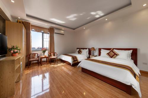a hotel room with two beds and a television at Airport Transit Hotel in Hanoi