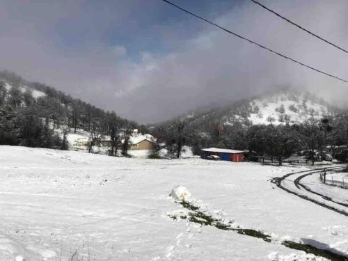 a snow covered field with a mountain in the background at Waxberry Getaway Sequoia/Kings Canyon National Pks in Squaw Valley