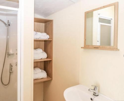 a bathroom with a sink and a mirror and towels at Charming and peaceful 2-Bed Chalet in Hampshire in Warsash