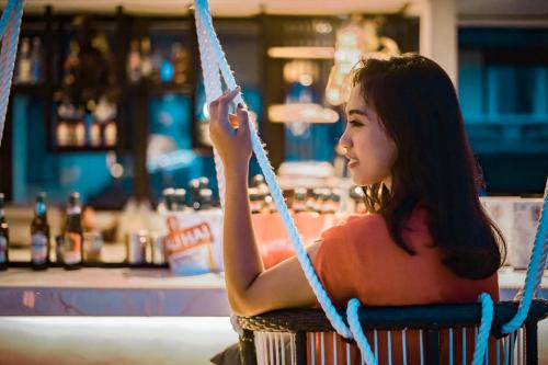 a woman sitting in a chair holding a rope at Amed Cafe & Hotel Kebun Wayan in Amed