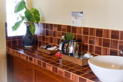 a tiled counter with a sink and a plant on it at Amed Cafe & Hotel Kebun Wayan in Amed